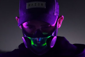 Man in a baseball cap wearing a glowing mask.